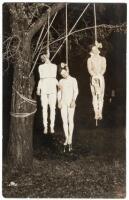 Real-photo postcard showing of three men hung by the neck from a tree - the second-to-the-last lynching in the American West