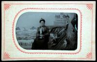 Tintype of an African American woman seated in a studio, with backdrop containing a depiction of San Francisco's Cliff House