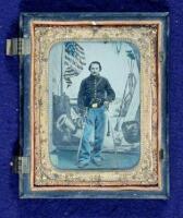 Tintype of a Union soldier in uniform, with gun and two swords, in studio setting