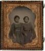 Original ambrotype photograph of two Los Angeles Latina women wearing patterned dresses, standing side-by-side, in leather case