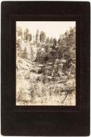 Original gelatin silver photograph of a hillside with what looks to be a boarded-up entrance to a mine