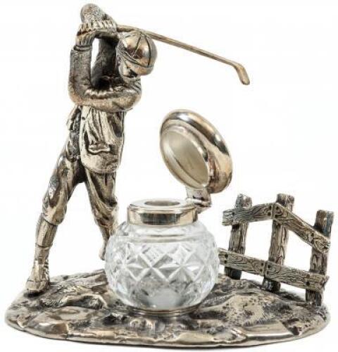 Glass inkwell, set within a metal golfing scene