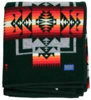 Beaver State Pendleton blanket, on green background with pattern in red tones