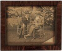 Original photograph of John Muir and John Burroughs sitting in chairs outside in yard, signed by John Burroughs on mount beneath image