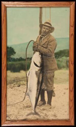 Large hand-colored photograph of Zane Grey holding a yellowtail