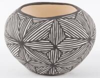 Small white pot with intricate design in black