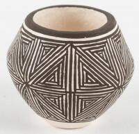 Very small white pot with intricate geometric designs