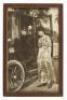 Original photograph of a young woman standing next to an early electric-powered car
