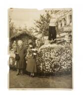 Original Associated Press photograph of Albert Einstein and his wife Elsa standing next to a flower-covered float at the Tournament of Roses in Pasadena, California