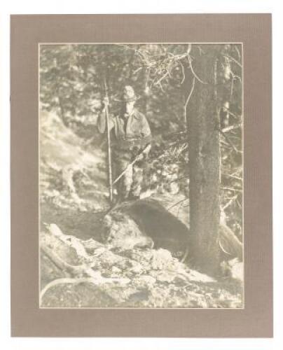 Original photograph of Saxton Pope standing over a grizzly bear he had just shot with a bow and arrow, both of which he holds