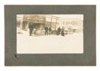 Photograph of a street in Dawson City, Canada, just across the border from Alaska, with two sleds loaded and ready to move out