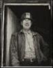 Photograph of a worker in hard hat and denim jacket, wearing glasses