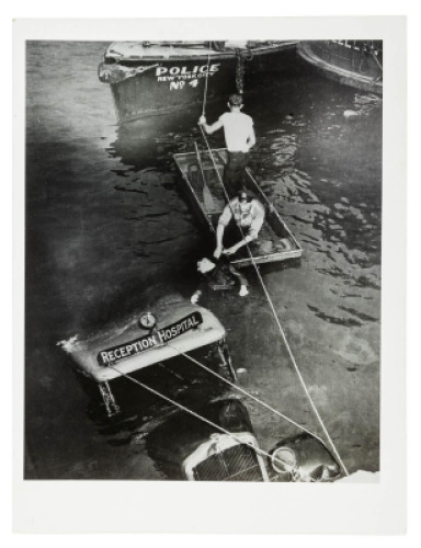 Untitled [Police officer and assistant removing body of Reception Hospital ambulance driver Morris Linker from East River, New York]