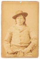 Vintage albumen cabinet photograph of a Native American man seated, holding a revolver