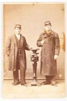 Cabinet card portrait of two conductor's in heavy coats, one with elaborate watch chain