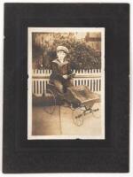 Boy Sitting in Spoked Wheel Toy Car