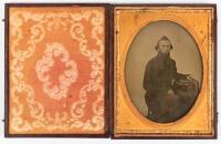 Ambrotype of seated gentleman with left arm resting over a book laid on posing table