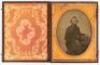 Ambrotype of seated gentleman with left arm resting over a book laid on posing table