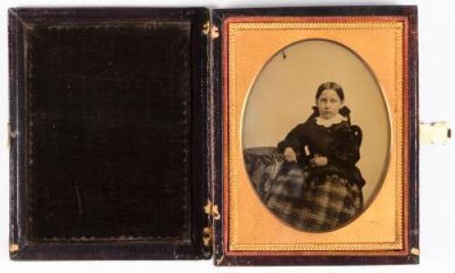 Ambrotype portrait of seated girl with right arm resting on posing table
