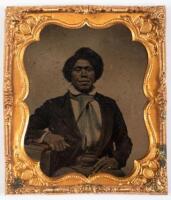 Tintype of seated African American, arm resting over a book with gold rings on both little fingers