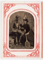 Tintype of young couple finely dressed, elaborate posing set, posing with tennis racket