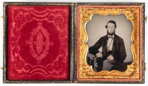 Ambrotype portrait of seated gentleman with arm resting on posing table