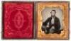 Ambrotype portrait of seated gentleman with arm resting on posing table