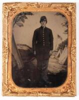 Union soldier in cap and dress uniform posing in front of patriotic backdrop