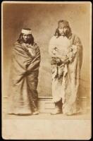 Photograph of two Indians in studio setting, standing, wrapped in buffalo hide robes