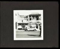 Album with 32 black & white snapshot photographs of buildings and streets in Sacramento, California, most with automobiles
