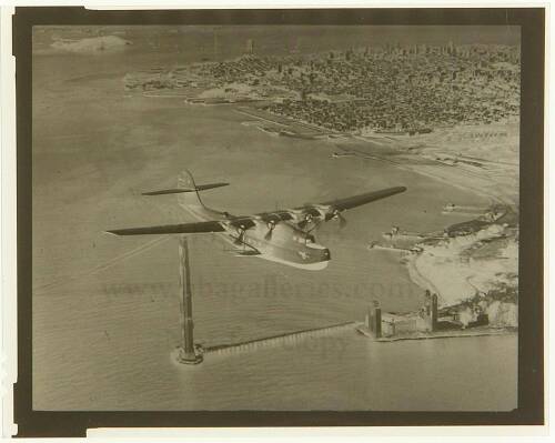 Photographic negative of a flying boat above the Golden Gate Bridge during construction