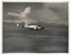 Gelatin silver photograph of Amelia Earhart's Lockheed HE Electra in flight over the water