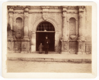 Original photograph of the "Front of the Alamo" with a man and a young boy standing in the doorway