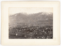 Bird's-eye view photograph of the scattered buildings of Santa Barbara backed by the snow-capped Santa Ynez mountains