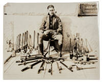 Original photograph of Deputy Sheriff Charles Joseph Ogle, Sacramento County, seated on a stool surrounded by several dozen opium pipes and other paraphernalia