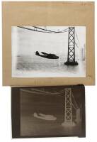 Photographic negative of a "China Clipper" large flying boat under the San Francisco Bay Bridge during construction