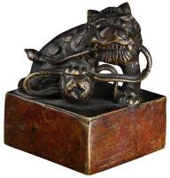 Bronze seal, likely Japanese, depicting a lion with one paw on a ball, its tail in its mouth.
