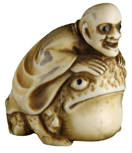 Carved Japanese ivory netsuke of man riding a toad