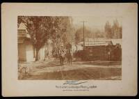 Albumen photograph of wagon-loads of lumber being pulled by horses through the town of Sonora