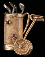 Gold charm of a golf bag with movable wheels with tiny mounted sapphires and rubies