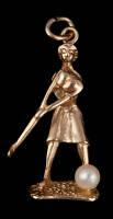 14K gold charm of a lady golfer figure, swinging at a golf ball which is a mounted pearl