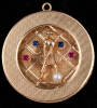 14K gold pendant, with figure of a lady golfer and mounted pearl, sapphires, and rubies